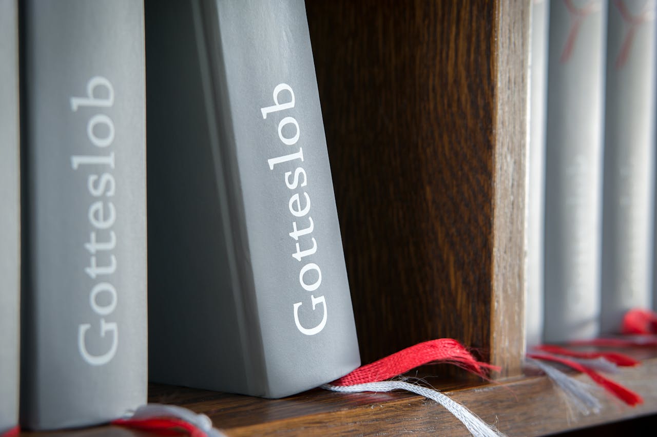 The Art of Drawing Readers In: Your attractive post title goes here Close-up of Gotteslob hymn books with red bookmarks on wooden shelf.